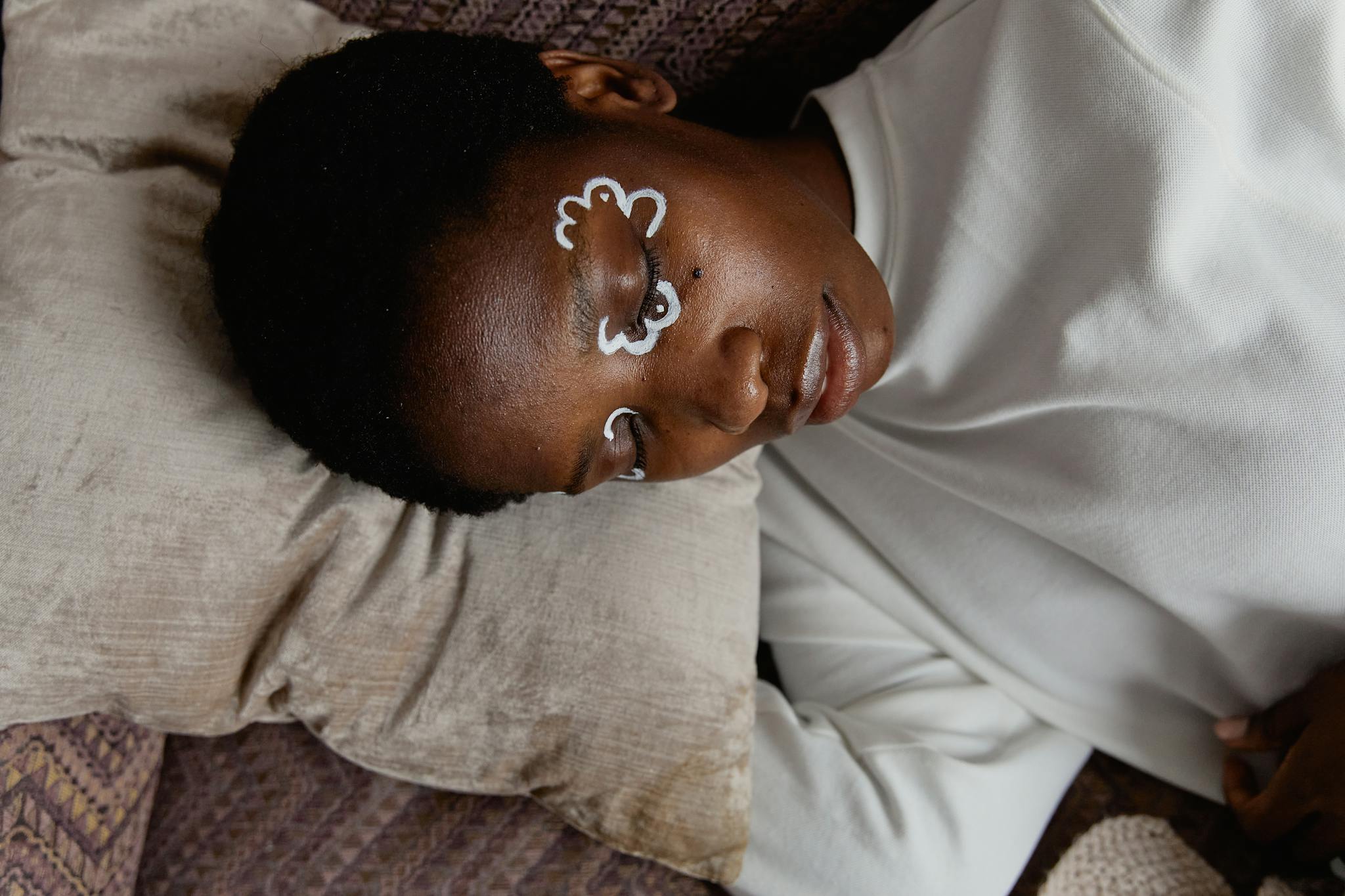 Calm woman resting in bed with eye cream, exuding tranquility and relaxation.